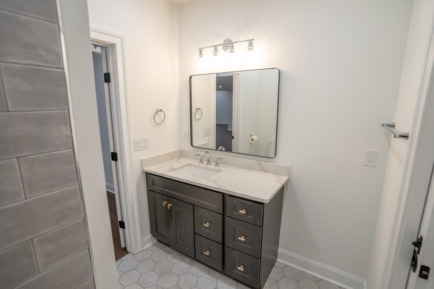 Luxury bathroom remodel by Couture in Chester County: gray shaker vanity, marble-look top and hexagon tile floor